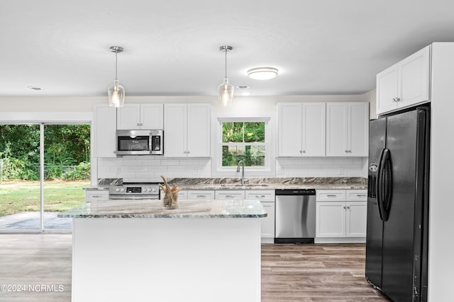 kitchen featuring stainless steel appliances, a wealth of natural light, and white cabinetry