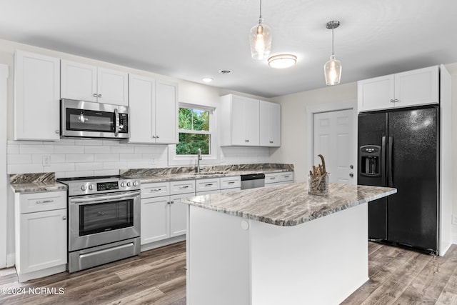 kitchen featuring pendant lighting, white cabinetry, a center island, and stainless steel appliances