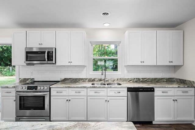 kitchen with dark hardwood / wood-style floors, appliances with stainless steel finishes, sink, and white cabinetry