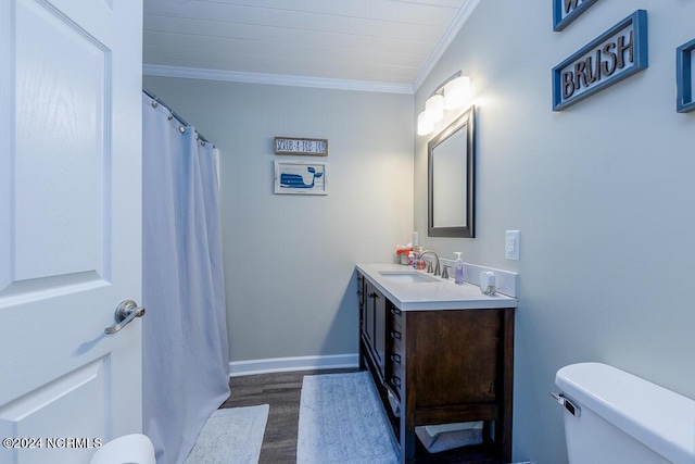 bathroom with toilet, wood finished floors, vanity, baseboards, and crown molding