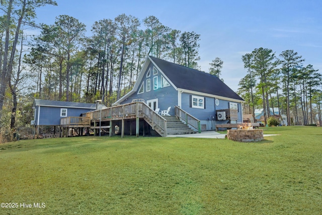 back of property featuring a lawn, stairway, a patio area, a deck, and a fire pit