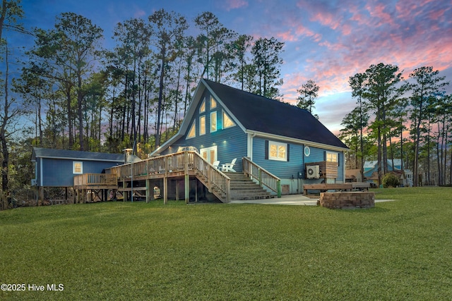 back of property featuring stairs, a lawn, and a wooden deck