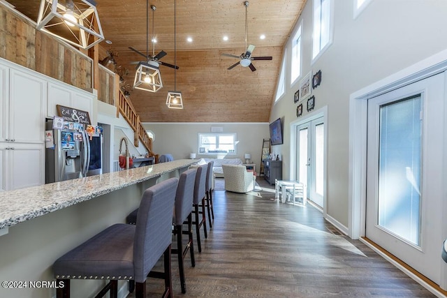 kitchen featuring wood ceiling, high vaulted ceiling, white cabinets, and stainless steel fridge with ice dispenser