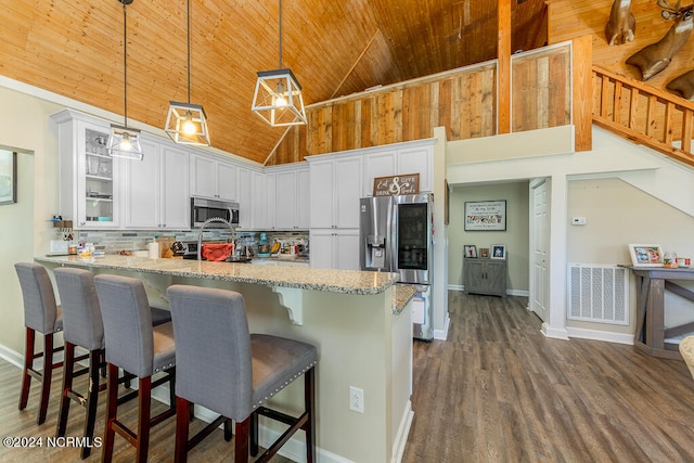 kitchen featuring tasteful backsplash, visible vents, appliances with stainless steel finishes, glass insert cabinets, and white cabinets