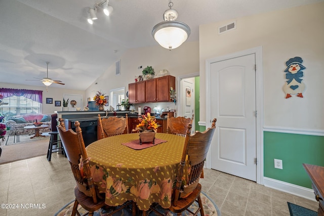 dining room featuring track lighting, ceiling fan, and vaulted ceiling