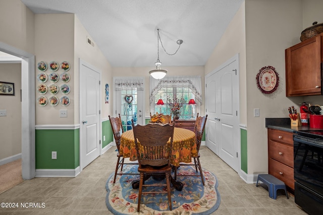 dining area featuring lofted ceiling and light tile patterned floors