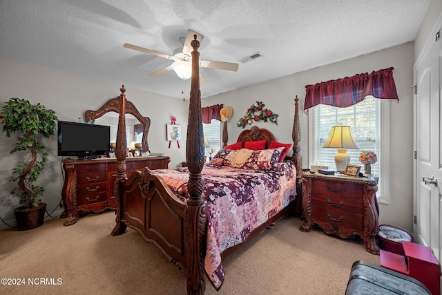 bedroom with a textured ceiling, ceiling fan, and light colored carpet