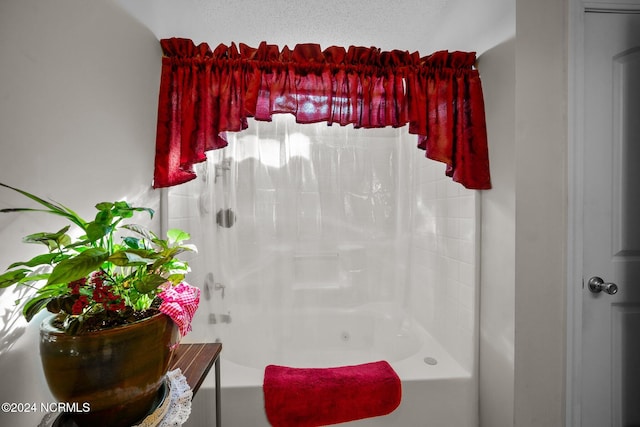 bathroom featuring shower / bathing tub combination and a textured ceiling