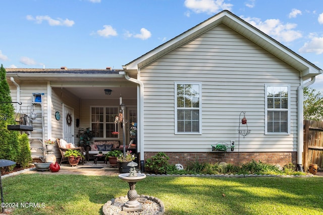 rear view of property featuring a yard