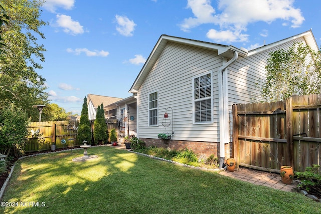 view of side of home with a yard