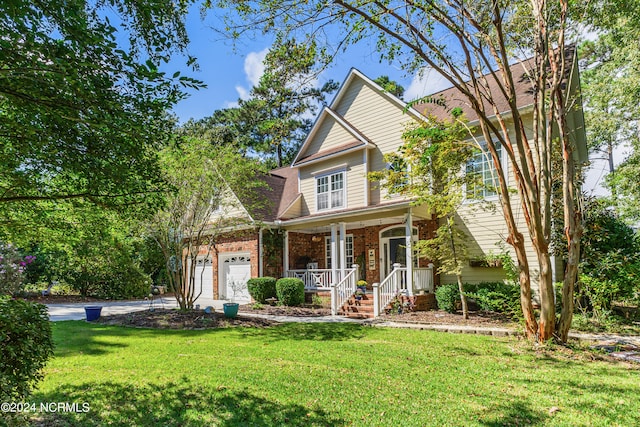 view of front of home with covered porch, a garage, and a front yard