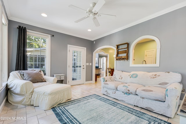 tiled living room with ornamental molding and ceiling fan