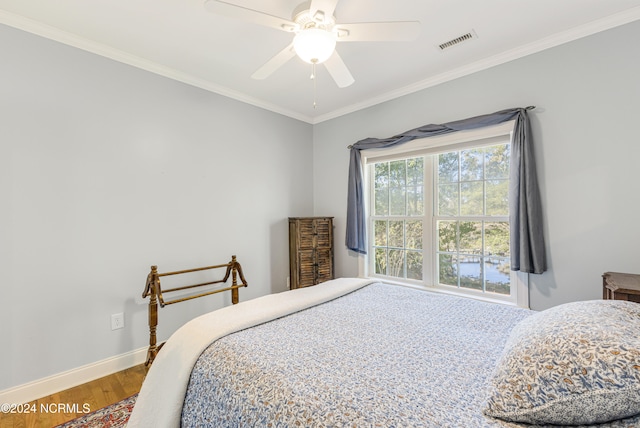 bedroom with ornamental molding, wood-type flooring, and ceiling fan