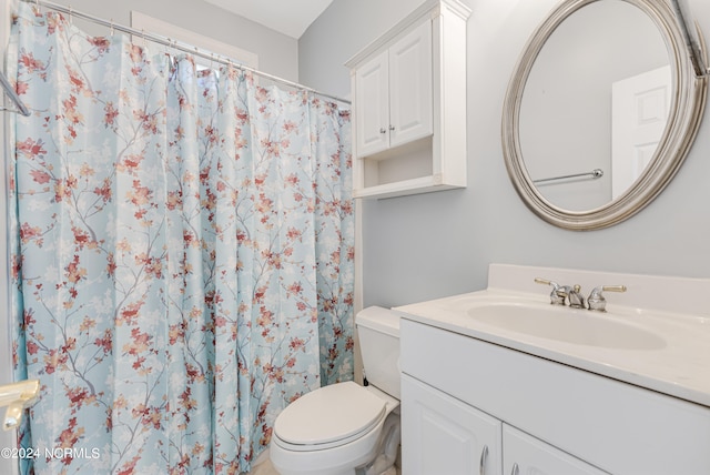 bathroom featuring toilet, vanity, and a shower with shower curtain