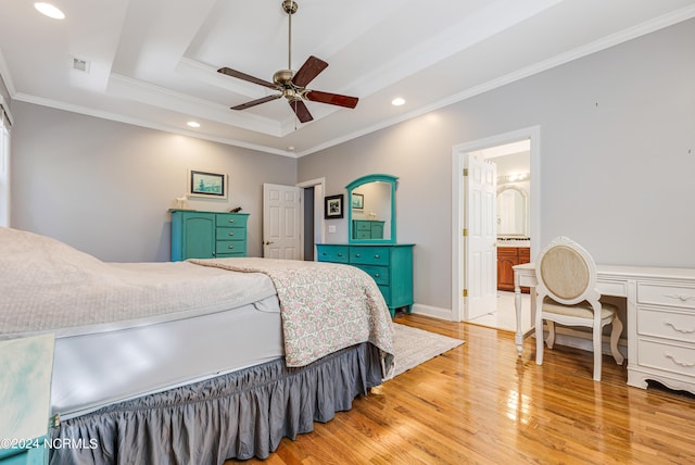 bedroom with a tray ceiling, ensuite bath, crown molding, light hardwood / wood-style floors, and ceiling fan