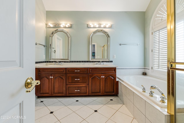 bathroom with vanity, tiled bath, and tile patterned flooring