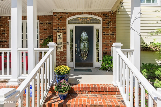 view of exterior entry featuring covered porch