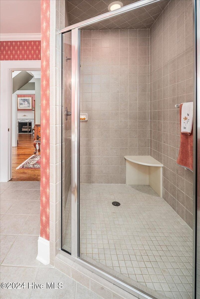 bathroom featuring ornamental molding, tile patterned flooring, and a shower with door