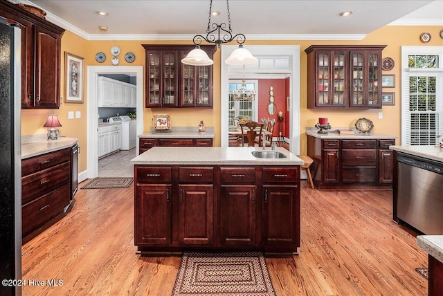 kitchen with light wood-type flooring, crown molding, washing machine and dryer, pendant lighting, and dishwasher