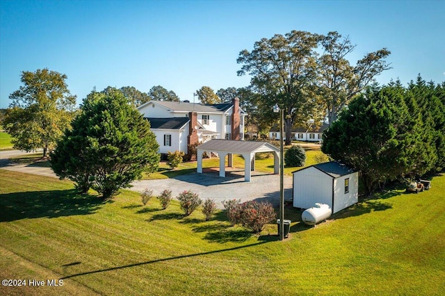 view of play area featuring a storage shed, a lawn, and a gazebo