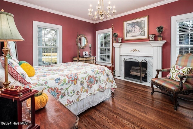 bedroom featuring a high end fireplace, crown molding, an inviting chandelier, and dark hardwood / wood-style flooring