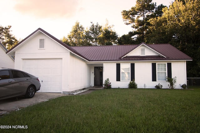 ranch-style home with a garage and a lawn