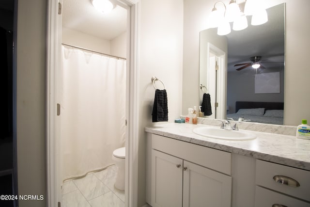 bathroom with a textured ceiling, ceiling fan with notable chandelier, vanity, and toilet