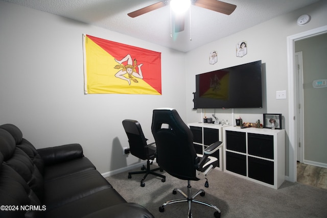 carpeted office with ceiling fan and a textured ceiling