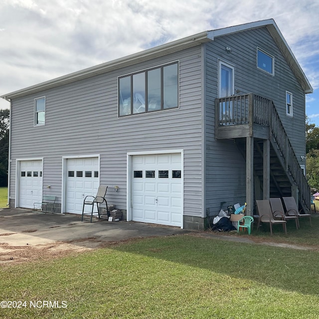 rear view of property featuring a garage and a yard