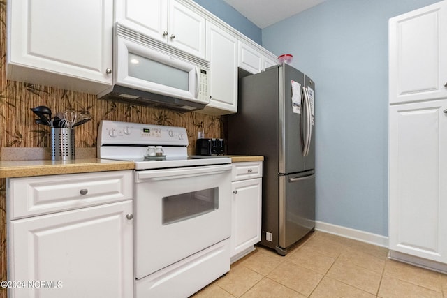 kitchen with white appliances, backsplash, light tile patterned floors, and white cabinetry