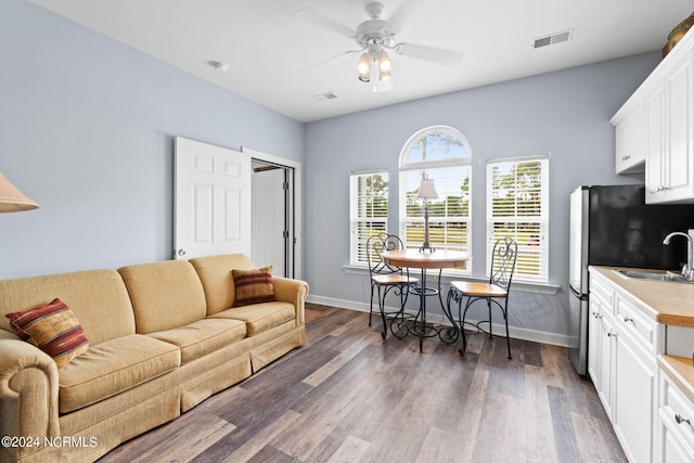 living room with ceiling fan, sink, and dark hardwood / wood-style floors