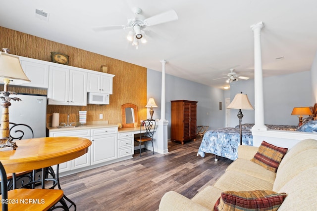 bedroom with ceiling fan, built in desk, hardwood / wood-style floors, sink, and white fridge