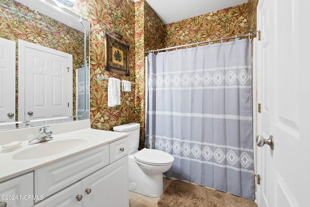 bathroom featuring curtained shower, vanity, and toilet