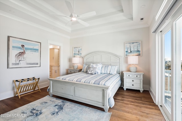 bedroom featuring baseboards, a tray ceiling, and wood finished floors