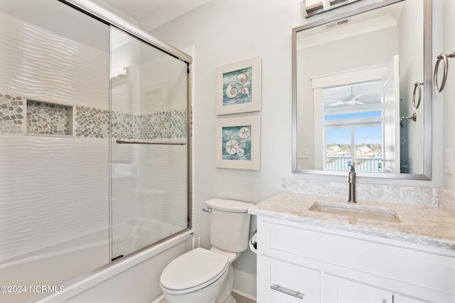 bathroom featuring enclosed tub / shower combo, visible vents, toilet, and vanity