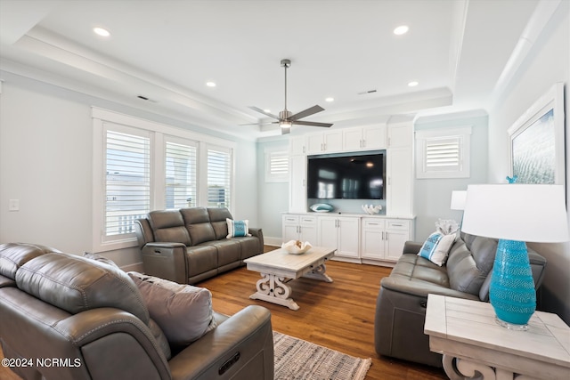 living room with wood finished floors, baseboards, recessed lighting, ceiling fan, and a raised ceiling