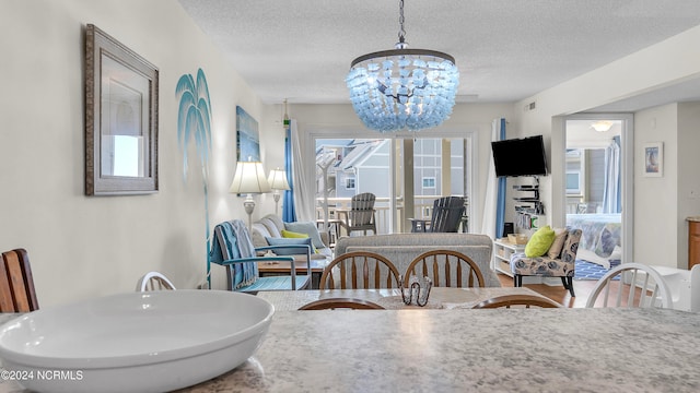 dining space featuring an inviting chandelier and a textured ceiling