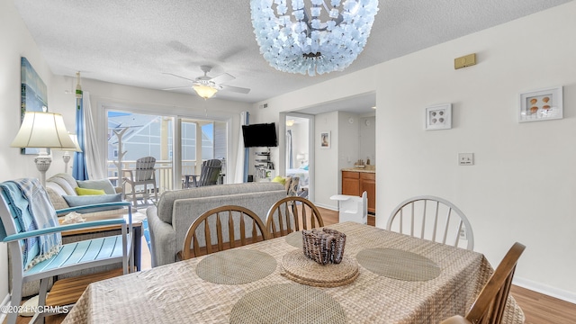 dining area with baseboards, a textured ceiling, ceiling fan, and wood finished floors