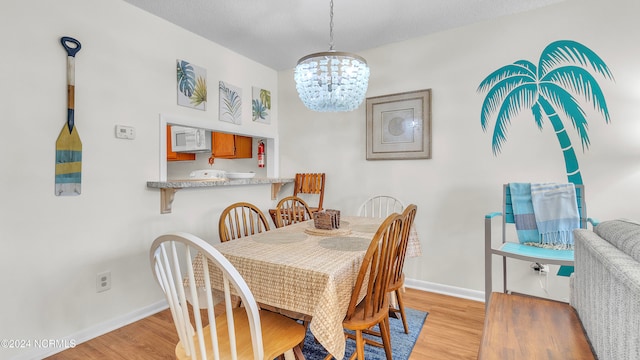 dining area with a chandelier and light wood-type flooring