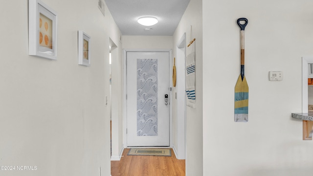 doorway featuring a textured ceiling and hardwood / wood-style flooring