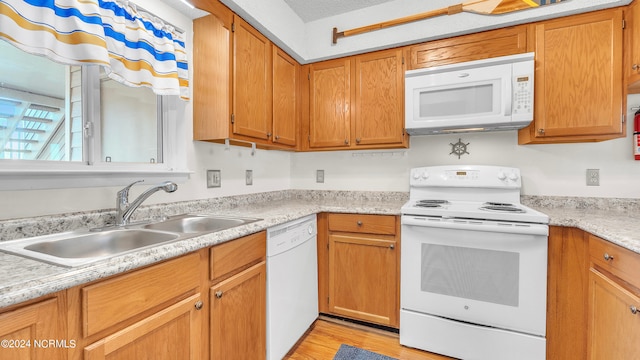 kitchen with a textured ceiling, light hardwood / wood-style flooring, sink, and white appliances