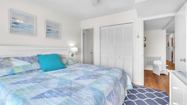 bedroom with a closet, dark hardwood / wood-style floors, and ceiling fan