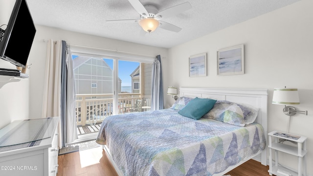 bedroom with a textured ceiling, ceiling fan, wood finished floors, and access to exterior