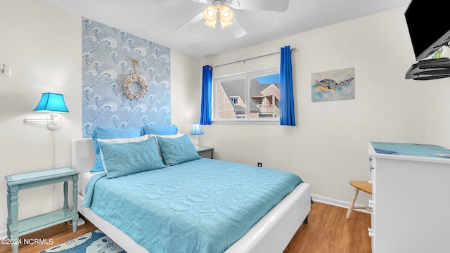 bedroom featuring wood-type flooring, a textured ceiling, and ceiling fan