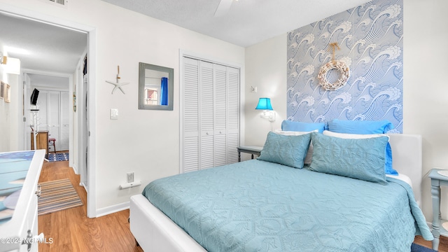 bedroom featuring ceiling fan, hardwood / wood-style flooring, and a closet