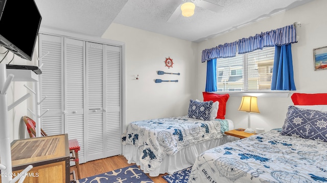 bedroom with ceiling fan, a textured ceiling, a closet, and hardwood / wood-style floors