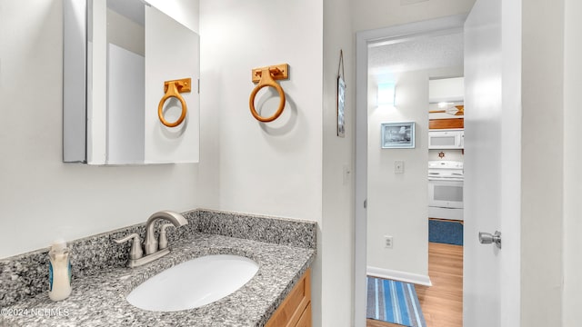 bathroom with vanity, hardwood / wood-style flooring, and a textured ceiling