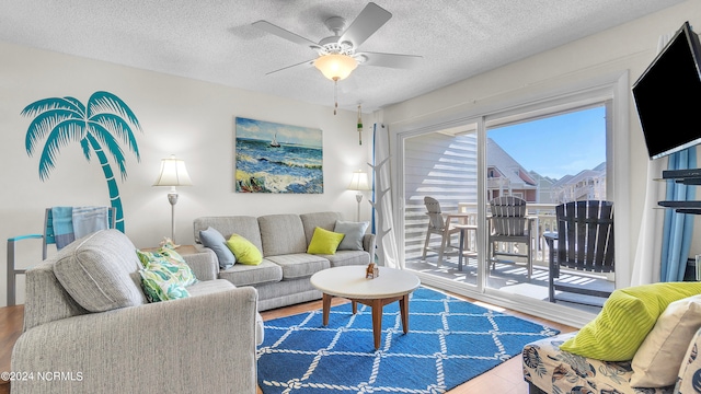 living room featuring ceiling fan, a textured ceiling, and hardwood / wood-style floors