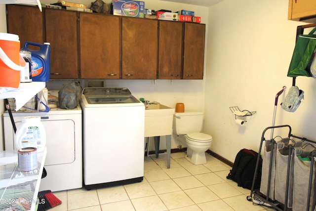 laundry area with washing machine and clothes dryer, sink, and light tile patterned floors