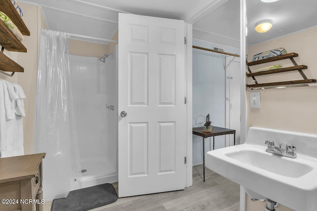 bathroom featuring sink, curtained shower, and hardwood / wood-style flooring